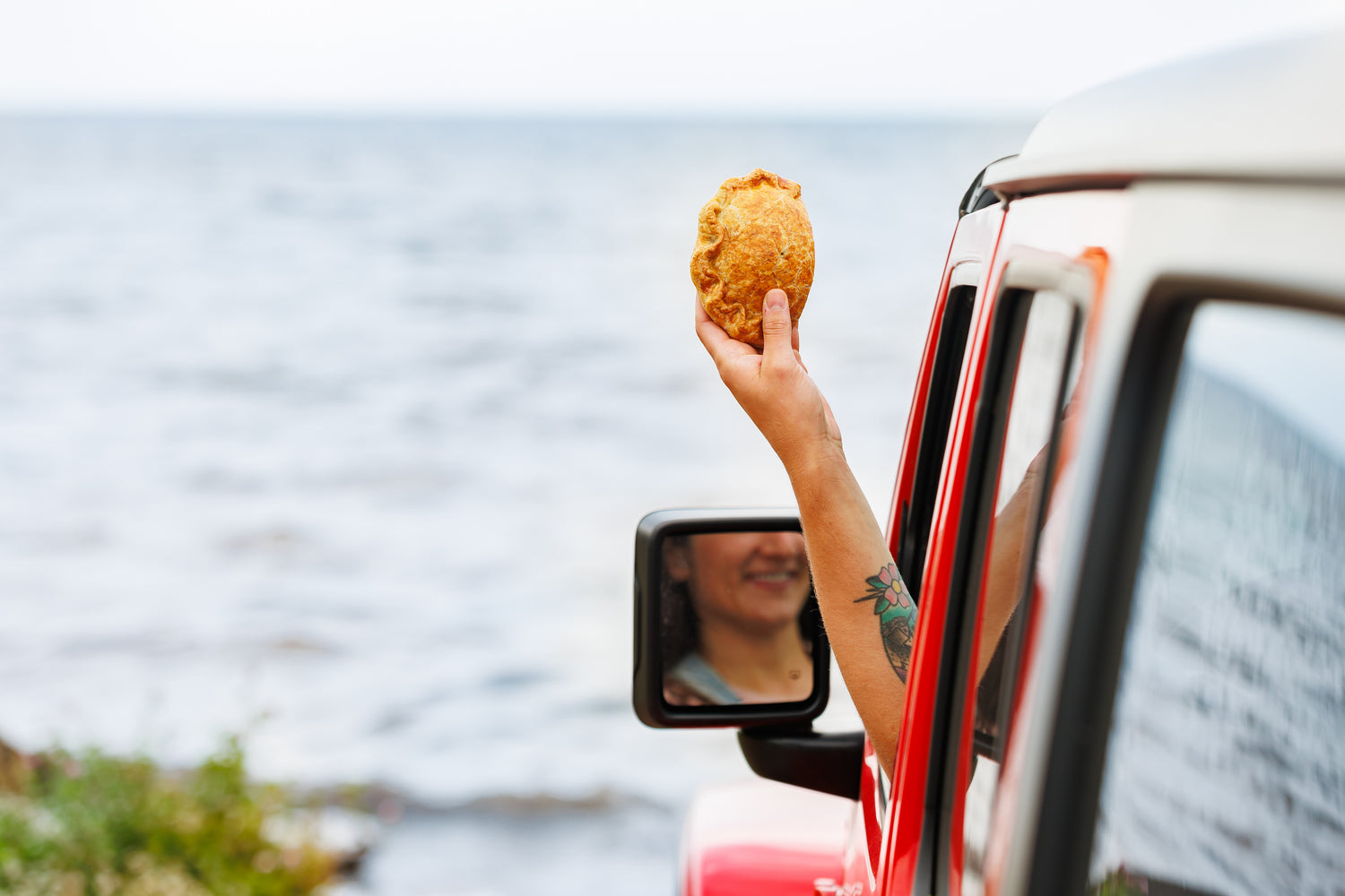 Cavendish beach food? Look no further than handpies, like this freshly toasted one being held out the car window right by the water