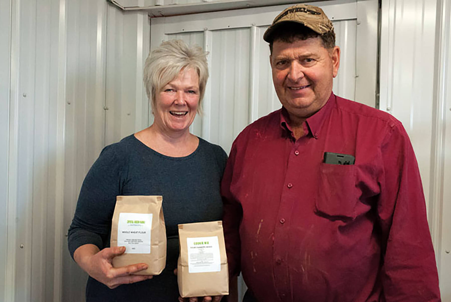 Two people from Crystal Green Farms showcasing the PEI flour we source for our handpies